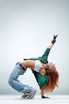 Moondance commercial dancer in a green jacket and jeans performing a one-handed backbend