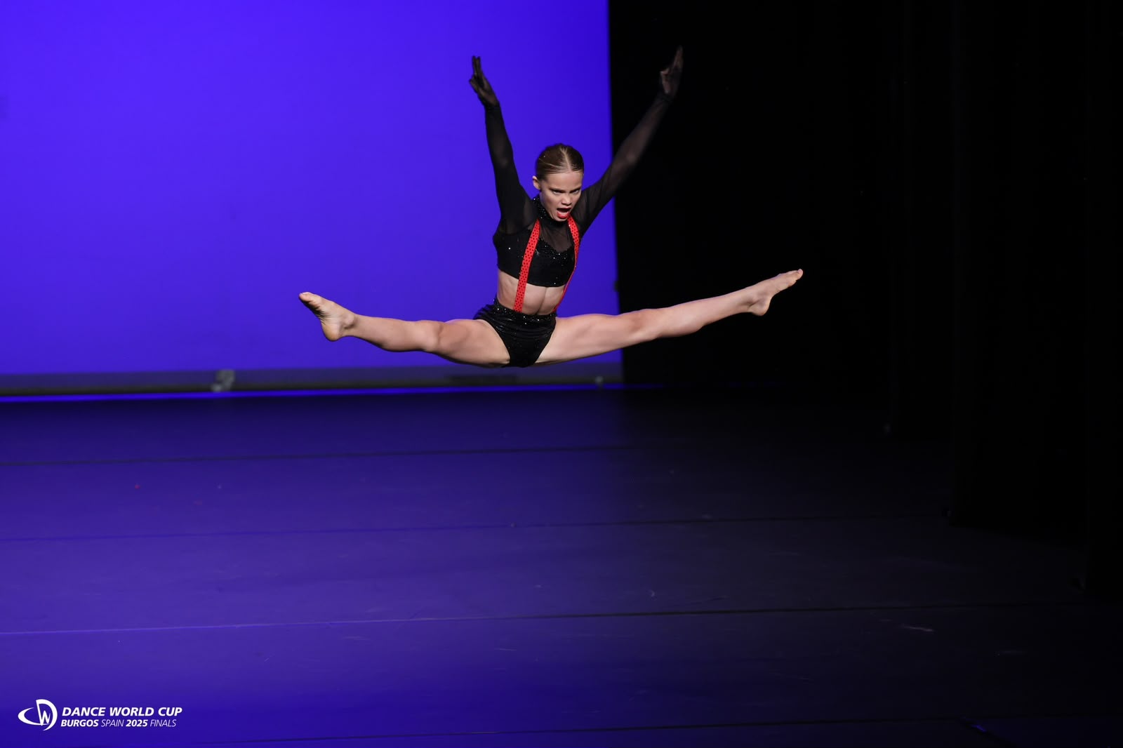 Moondance dancer in a mid-air split leap at the Dance World Cup finals